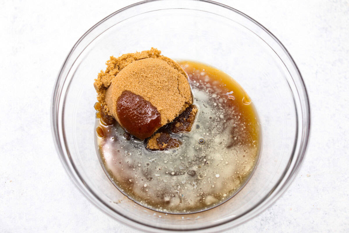Chocolate pecan pie is a sweet, decadent dessert with a buttery crust filled with gooey caramel, crunchy pecans, and rich chocolate. It's the perfect pie to share this Thanksgiving. It will knock your family's socks off! Overhead shot of butter, sugar, corn syrup in a glass bowl.