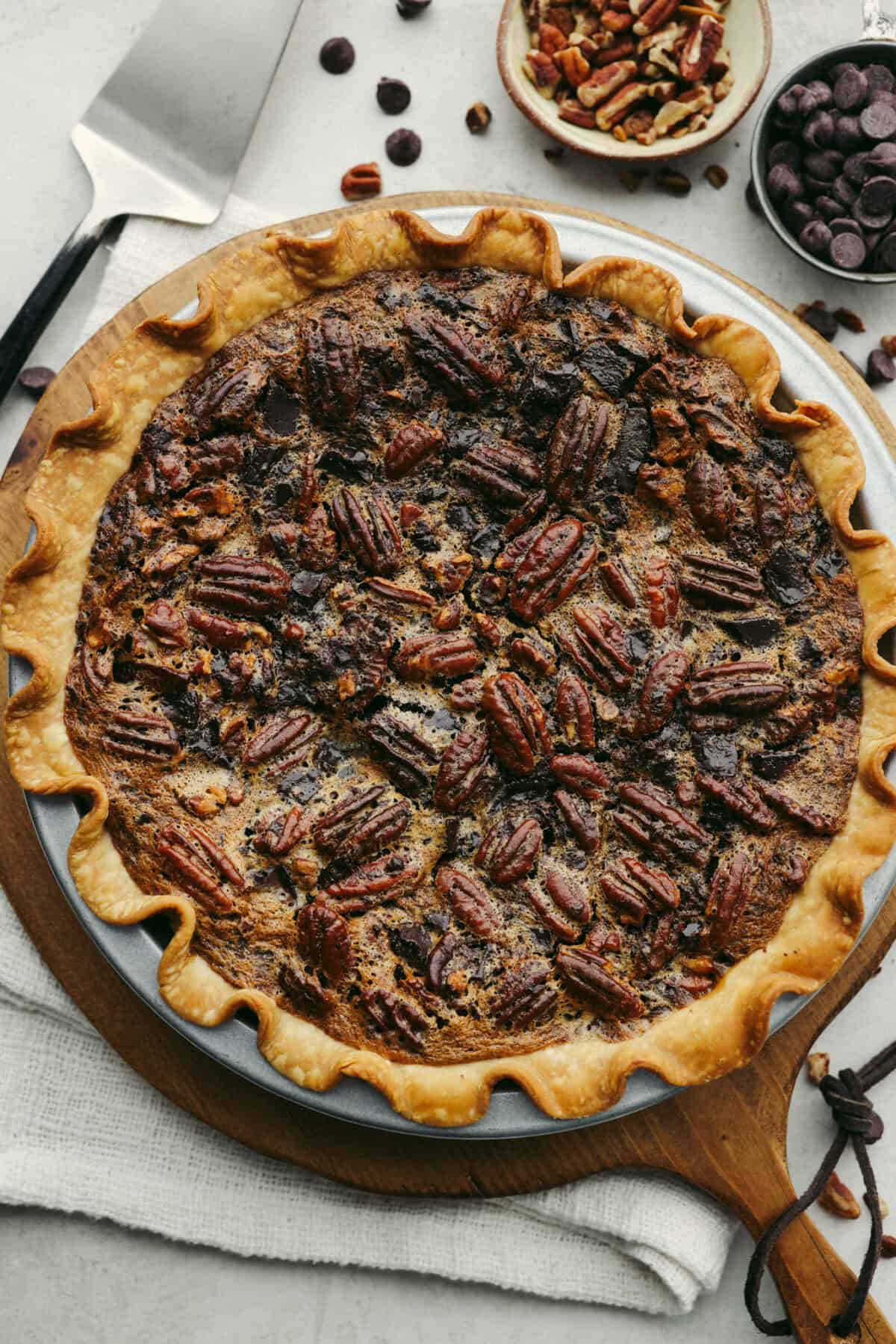Chocolate pecan pie is a sweet, decadent dessert with a buttery crust filled with gooey caramel, crunchy pecans, and rich chocolate. It's the perfect pie to share this Thanksgiving. It will knock your family's socks off! Overhead shot of baked chocolate pecan pie.
