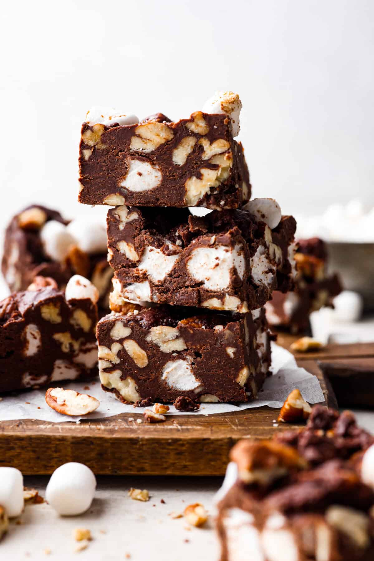 These decadent rocky road bars are the best no-bake treat that you can whip up in no time when that sweet tooth hits. Fudgy chocolate, soft marshmallows, and chewy pecans combine to make the most amazing dessert. Side shot of stacked rocky road bars