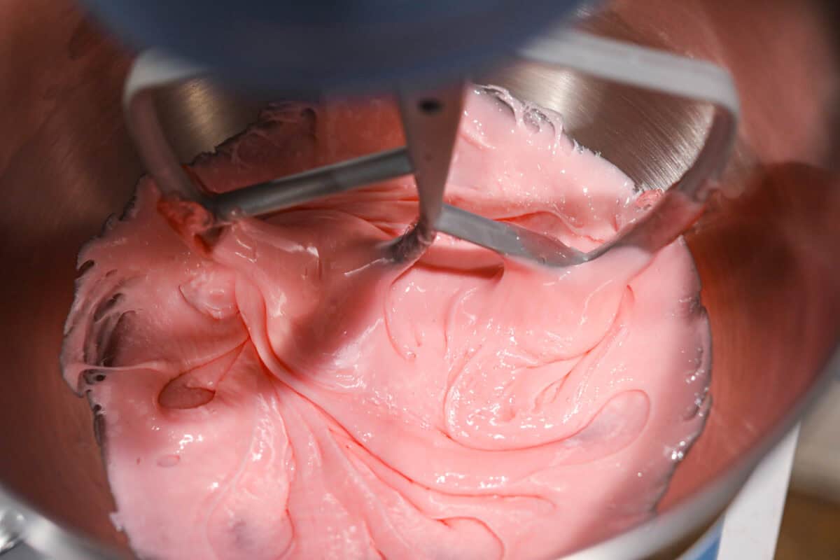 Homemade cherry cordials are a tasty, nostalgic treat! They're made with sweet cherries that are coated in a rich chocolate shell. Make them for Christmas or Valentine’s Day, and watch them disappear! Close up shot of fondant being mixed in a stand mixer.