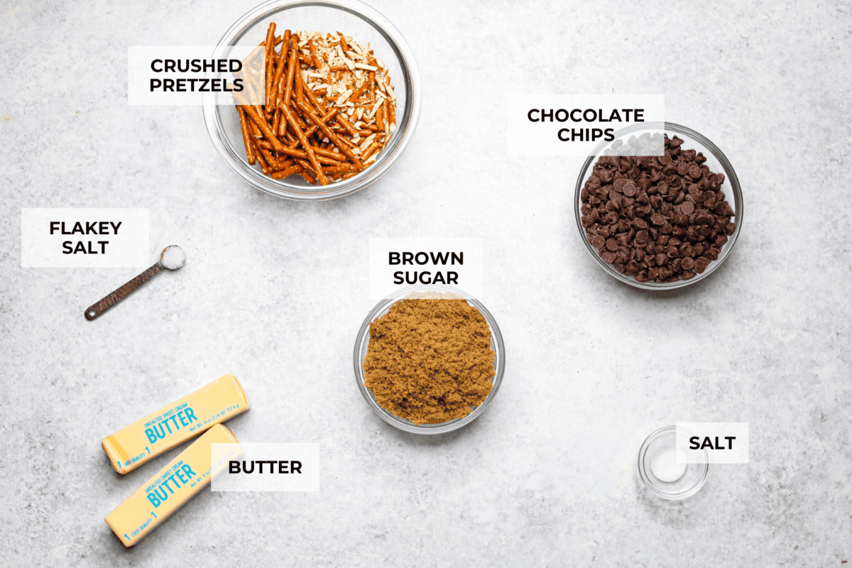 Pretzel Christmas Crack is the best holiday treat! This addictive combination of salty pretzels, rich toffee, and chocolate is sure to be a hit at any party or gathering. Overhead shot of labeled pretzel Christmas. crack ingredients.