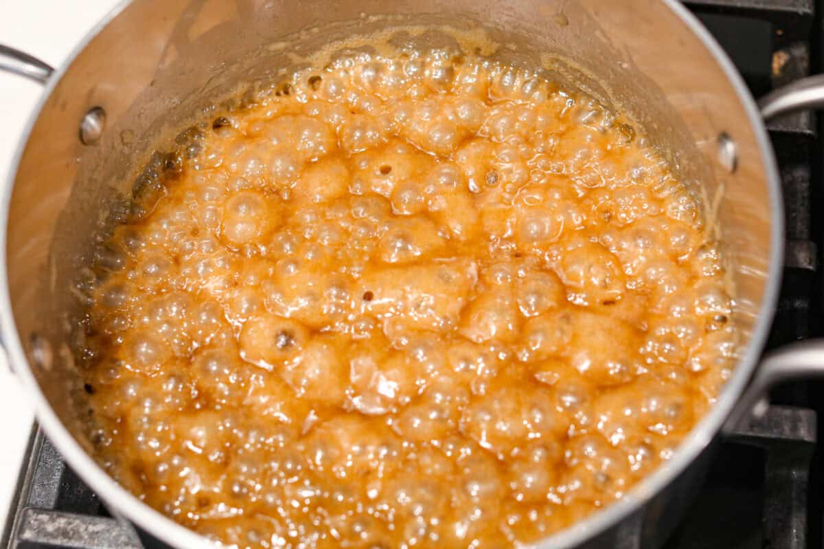 Pretzel Christmas Crack is the best holiday treat! This addictive combination of salty pretzels, rich toffee, and chocolate is sure to be a hit at any party or gathering. Overhead shot of caramel mixture boiling in a saucepan.