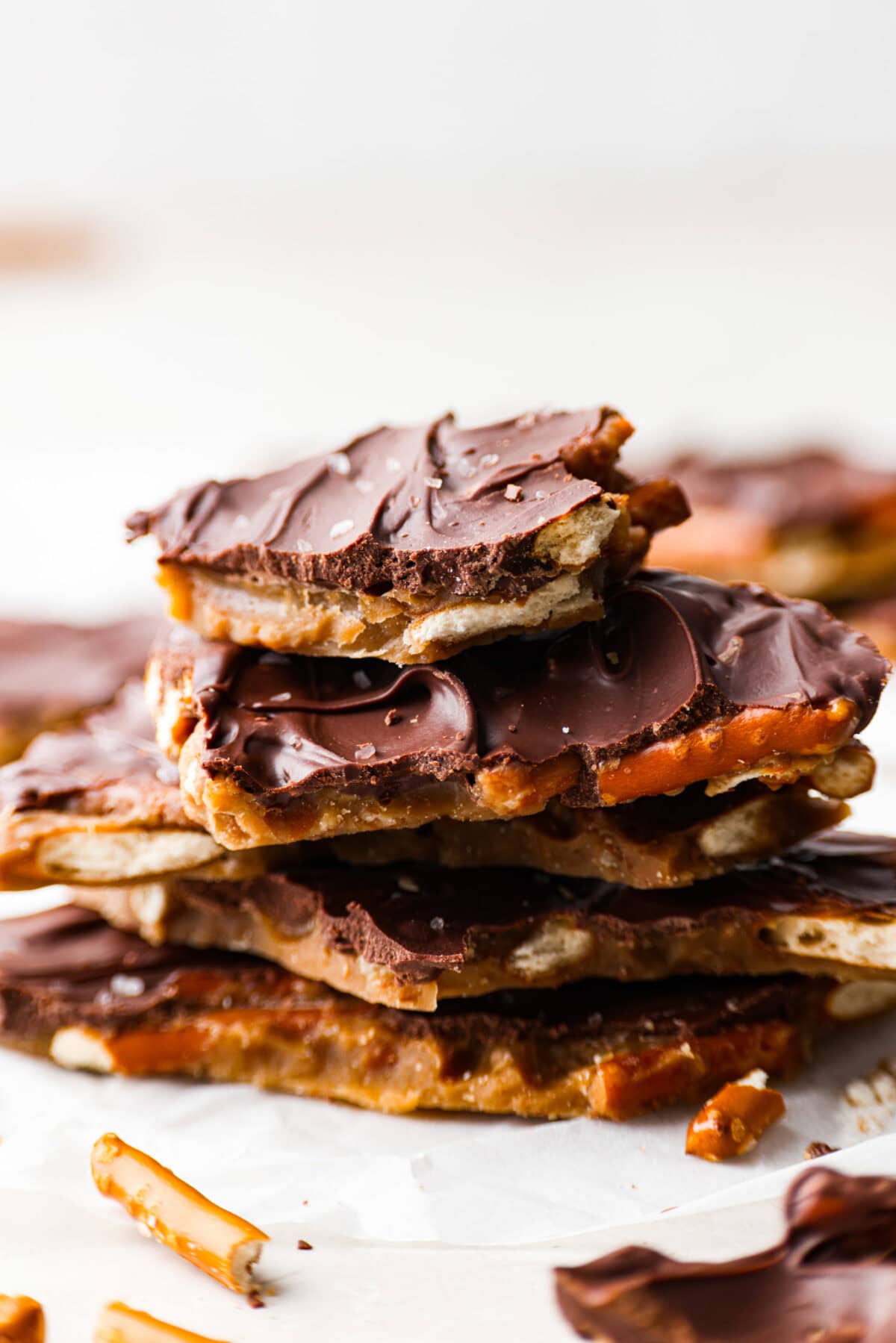 Pretzel Christmas Crack is the best holiday treat! This addictive combination of salty pretzels, rich toffee, and chocolate is sure to be a hit at any party or gathering. Side shot of a stack of broken Pretzel Christmas crack pieces.