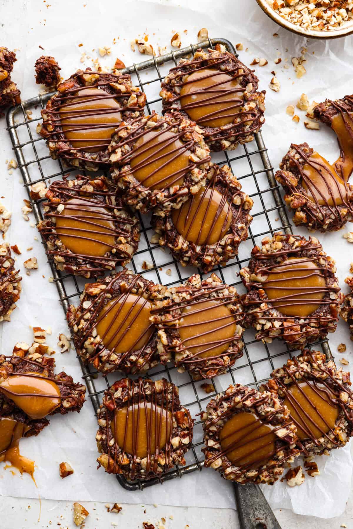 Turtle Cookies are a baked, bite-size brownie loaded with pecans, then filled with a creamy caramel center for a rich, decadent holiday cookie! These turtle cookies are always a huge hit and are gone in minutes Overhead shot of turtle cookies on a cooling rack.