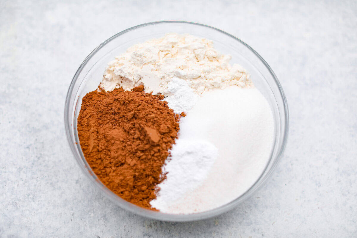 Chocolate Mayonnaise Cake is a rich, moist, and decadent dessert that’s super easy to make! The mayonnaise adds extra moisture and creates a soft, tender crumb. Whether for a special occasion or just because it's sure to impress! Overhead shot of flour, cocoa powder, and sugar in a bowl.