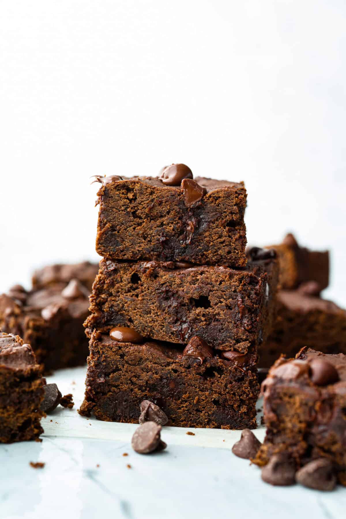 Black bean brownies are rich, fudgy, and packed with chocolatey goodness! They have a slightly denser texture, similar to a protein bar, but still satisfy that brownie craving. While adults may notice a slight difference from traditional brownies, kids won’t be able to tell! Side shot of stacked black bean brownies.