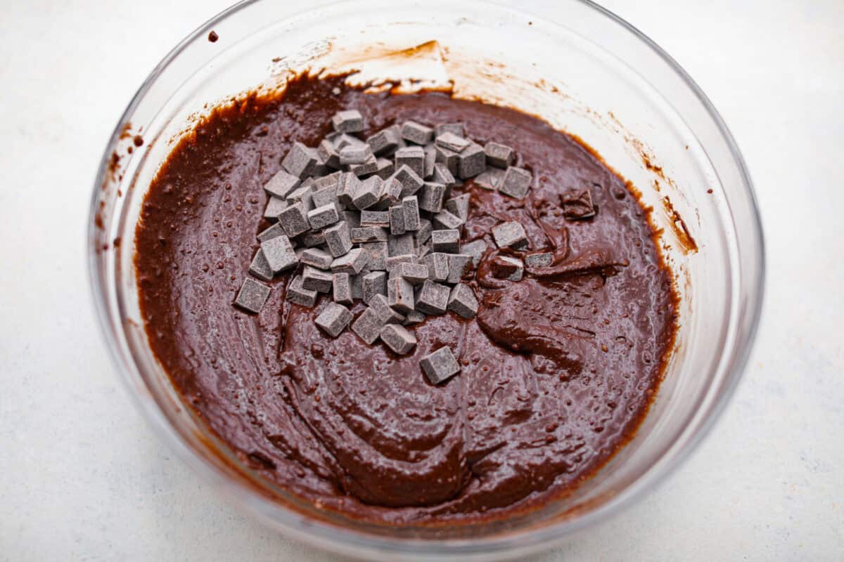 Rich, fudgy, and packed with deep chocolate flavor, Guinness Brownies are a must-try for any dessert lover! The stout beer enhances the cocoa, adding a subtle, malty depth of flavor that makes these brownies rich and irresistibly delicious. Overhead shot of chocolate chunks added to the mixed brownie batter.
