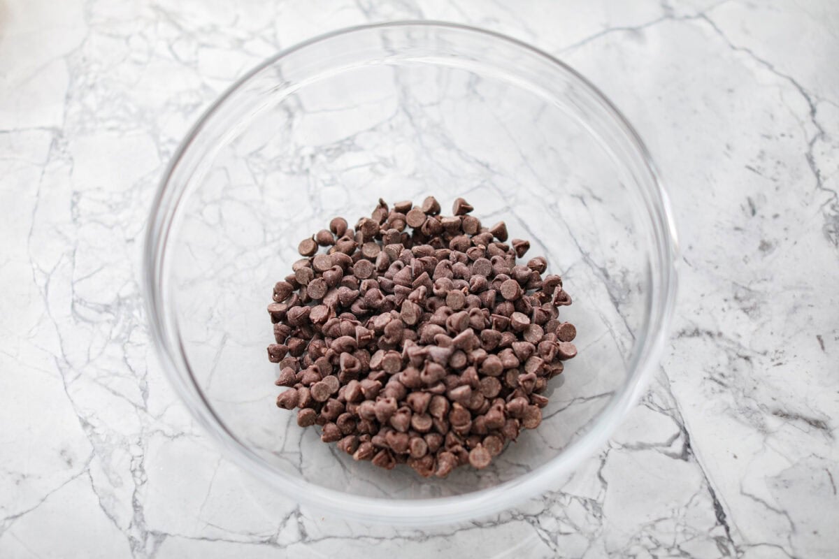 Rich, fudgy, and packed with deep chocolate flavor, Guinness Brownies are a must-try for any dessert lover! The stout beer enhances the cocoa, adding a subtle, malty depth of flavor that makes these brownies rich and irresistibly delicious. Overhead shot of chocolate chips in a bowl.